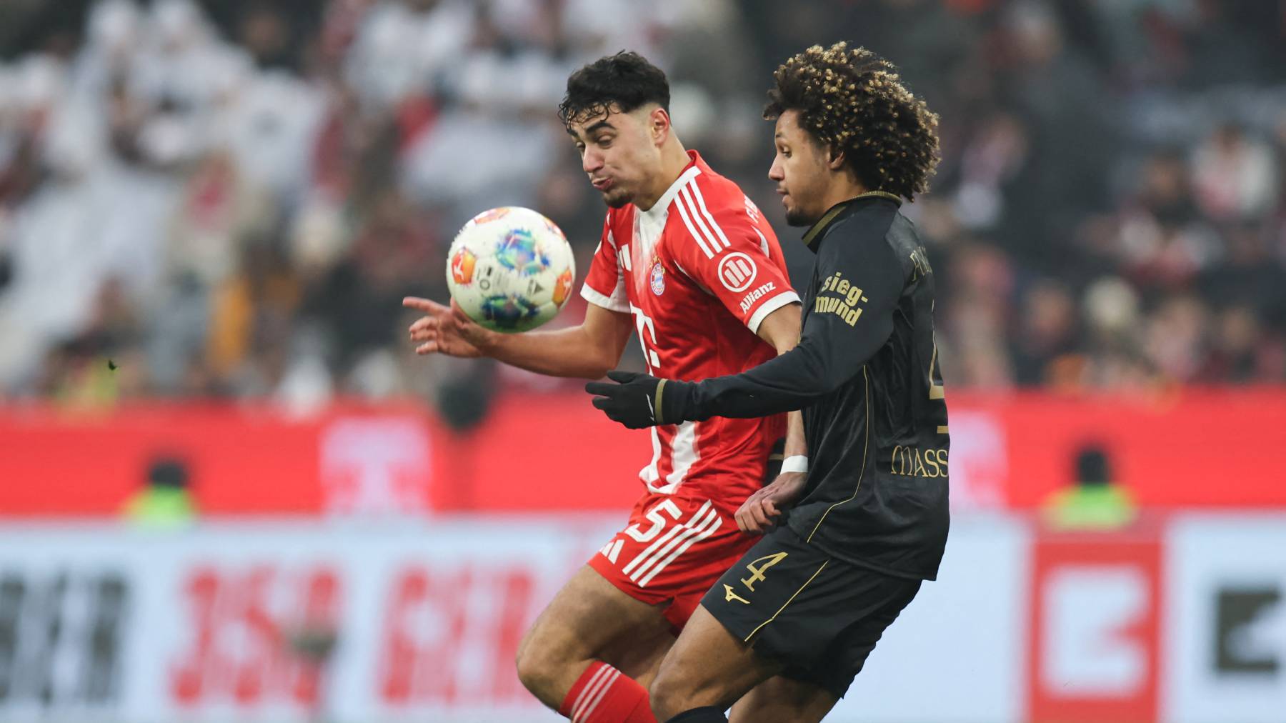 Bayern Munich's German midfielder #45 Aleksandar Pavlovic and Augsburg's French midfielder #04 Han-Noah Massengo vie for the ball during the German first division Bundesliga football match between FC Bayern Munich and FC Augsburg in Munich, southern Germany, on January 24, 2026.