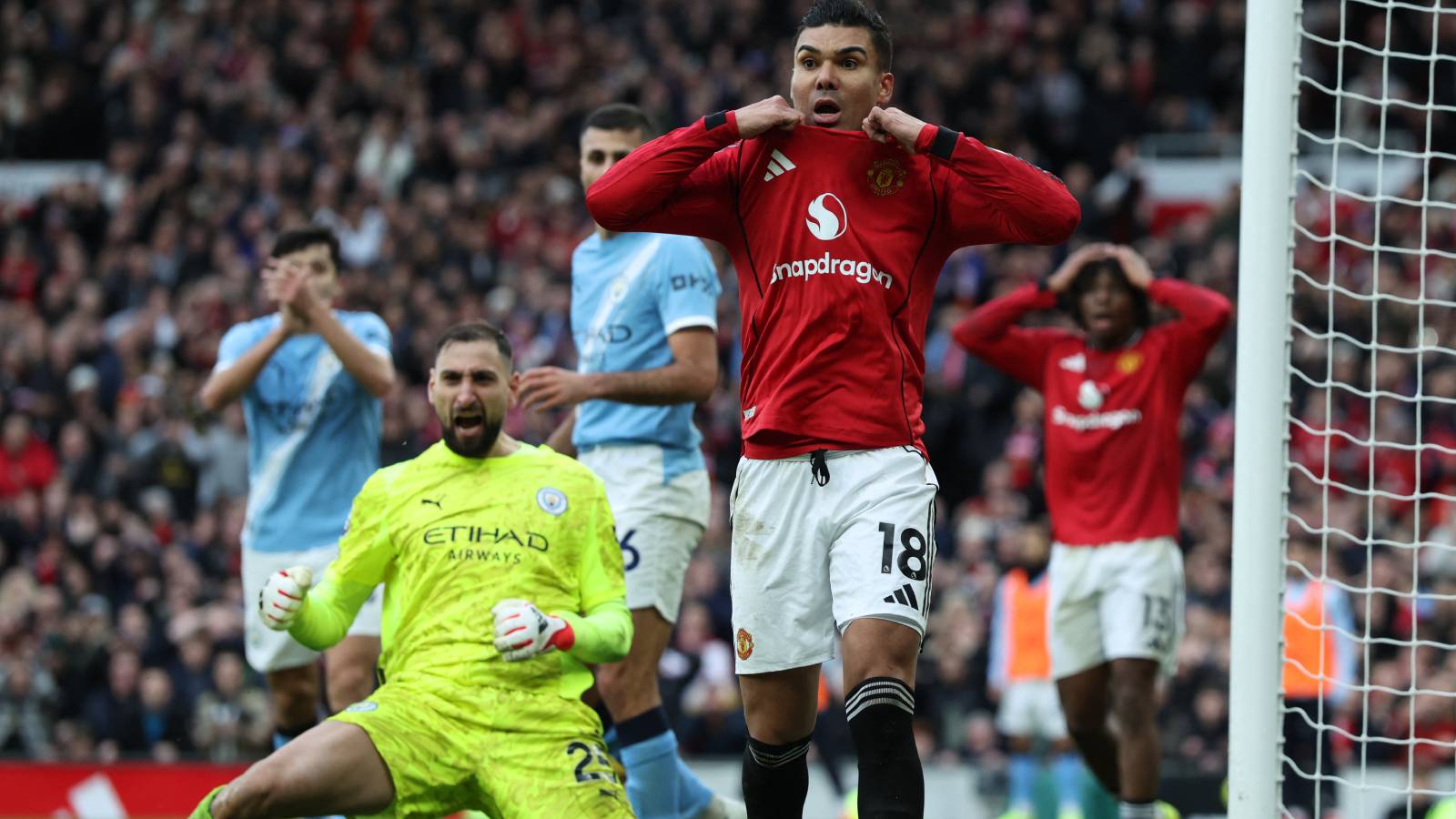 Manchester United's Brazilian midfielder #18 Casemiro (C) reacts to a missed chance as Manchester City's Italian goalkeeper #25 Gianluigi Donnarumma (L) celebrates during the English Premier League football match between Manchester United and Manchester City at Old Trafford in Manchester, north west England, on January 17, 2026.
