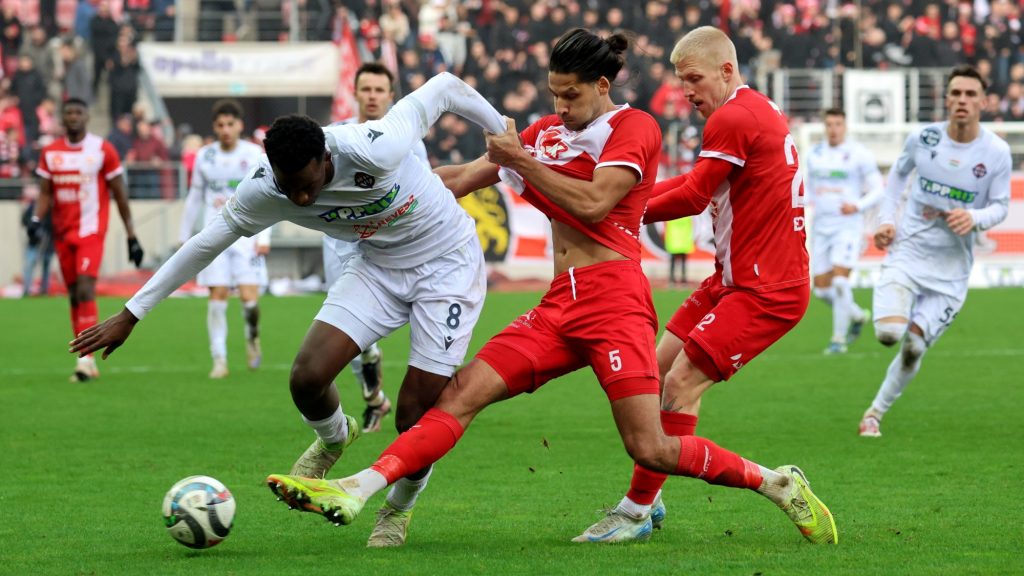 Kecskés Ákos (k) és Bokros Szilárd (j), a Diósgyőri VTK és Dantaye Gilbert, a Nyíregyháza játékosa (b) a labdarúgó Fizz Liga 16. fordulójában játszott Diósgyőri VTK - Nyíregyháza Spartacus FC mérkőzésen a diósgyőri DVTK Stadionban 2025. december 6-án. A Diósgyőr 2-0-ra győzött.