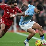 Manchester City's English midfielder #33 Nico O'Reilly (R) is challenged by Liverpool's Hungarian midfielder #08 Dominik Szoboszlai (L) during the English Premier League football match between Liverpool and Manchester City at Anfield in Liverpool, north west England on February 8, 2026.