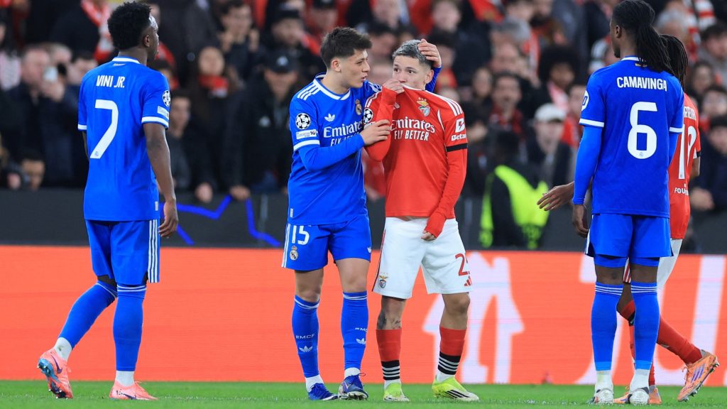 Gianluca Prestianni, miközben a száját eltakarva odaszól Vinícius Juniornak.