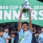 Manchester City's English midfielder #33 Nico O'Reilly poses with the trophy as City players celebrate after the English League Cup final football match between Arsenal and Manchester City at Wembley Stadium in London on March 22, 2026. Nico O'Reilly scored both goals as City won the game 2-0.