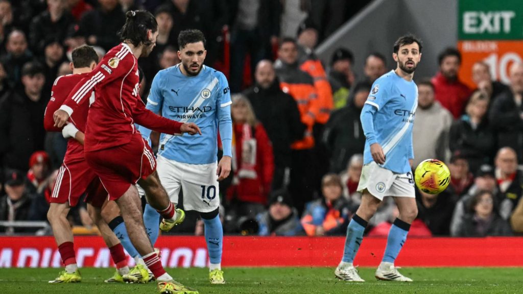 Liverpool's Hungarian midfielder #08 Dominik Szoboszlai (front L) scores from a free kick for his team's first goal during the English Premier League football match between Liverpool and Manchester City at Anfield in Liverpool, north west England on February 8, 2026.