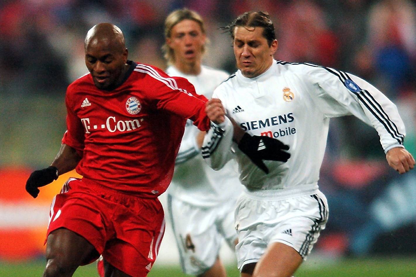 Ze Roberto (left) of Bayern Munich runs with the ball as he is followed by Real Madrid player Michel Salgado during the Champions League match between FC Bayern Munich and Real Madrid in Munich on Tuesday, 24 February , 2004.